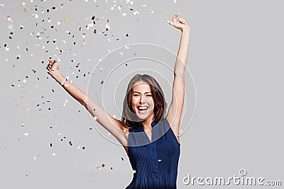 Beautiful happy woman at celebration party with confetti falling everywhere on her. Birthday or New Year eve celebrating concept Stock Photo