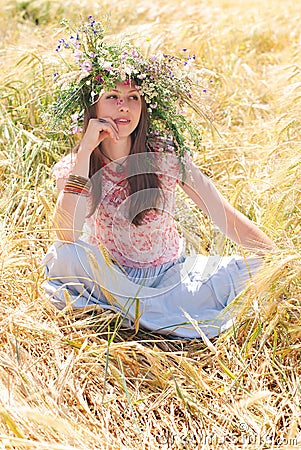 Beautiful happy woman in flower wreath in summer Stock Photo