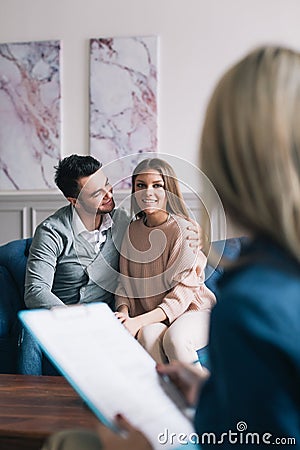 Beautiful and happy young couple visiting psychologist for relationship counselling. Stock Photo