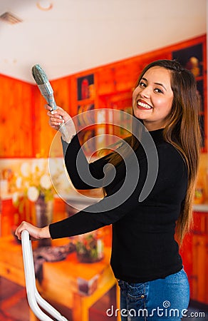 Beautiful happy young woman painting using brush Stock Photo