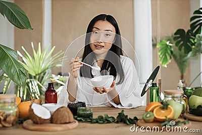 Beautiful healthy asian woman mixing the mass in a bowl while preparing cream. Stock Photo