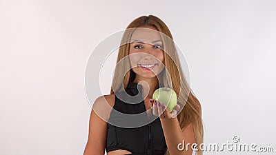 Beautiful healthy woman smiling, holding out delicious apple to the camera Stock Photo