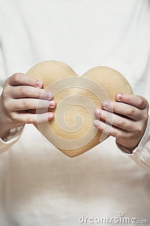 Beautiful heart made of wood in children hands Stock Photo