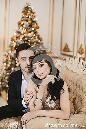 Beautiful heterosexual couple posing together in the luxury interior decorated for Christmas Stock Photo