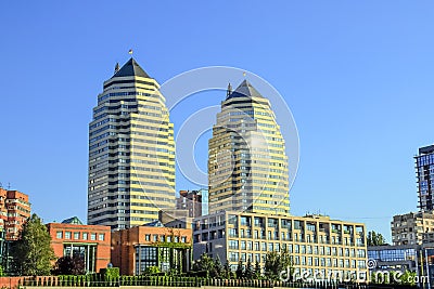 Beautiful high brick skyscrapers, towers and buildings in white and orange with a sun flare. View of the Dnipro city Stock Photo