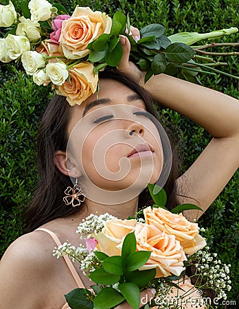 beautiful hispanic indigenous model wearing a peace dress flower crown roses flowers nature trees Stock Photo