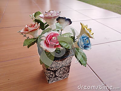 beautiful home accessories a flower replica made of ceramic (rose replica). brown floor as background Stock Photo