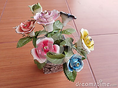 beautiful home accessories a flower replica made of ceramic (rose replica). brown floor as background Stock Photo