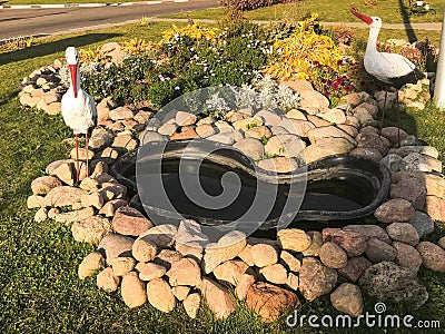 Beautiful homemade stone pond of cobblestones on the street under the open sky. Homemade landscape design Stock Photo