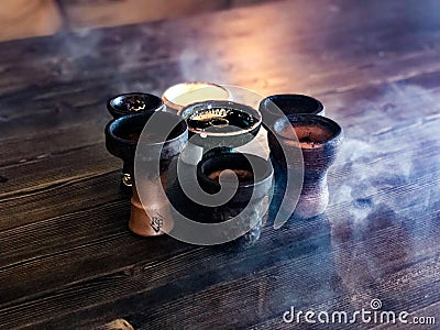Beautiful hookah bowls made of ceramic stand in the smoke Stock Photo