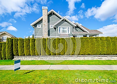 Beautiful house behind a green hedge fence Stock Photo