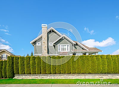 Beautiful house behind a green hedge fence Stock Photo