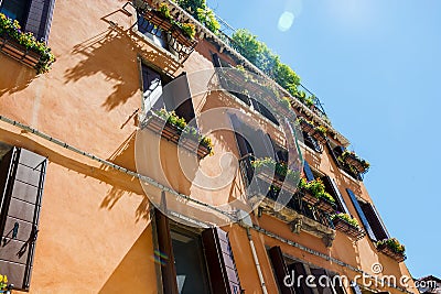 Beautiful house facade with windows and shutters in flowers in Venice, Italy Stock Photo