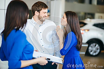 Young married couple buying their first car together in auto salon Stock Photo