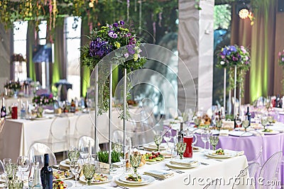 Beautiful hydrangea bouquets in vases on high stands. Flower arrangement on tables at luxury wedding reception in Stock Photo