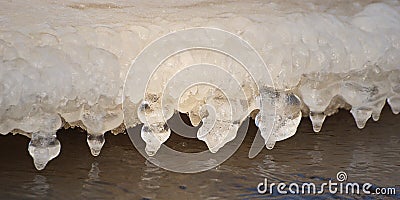 Beautiful icicles formed by a flowing river in winter day Stock Photo