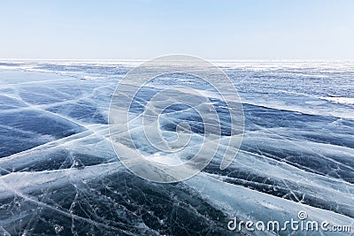 Winter landscape of frozen Lake Baikal with a blue ice surface with cracks to the horizon Stock Photo