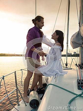 Beautiful image of romantic couple in love looking at each other on yacht at sunset Stock Photo