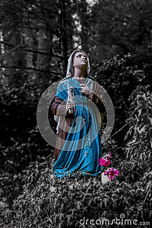 Image of a statue of Bernadette praying to Our Lady of Lourdes Stock Photo