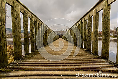 Beautiful image of a way on a wooden bridge leading to a gazebo in the middle of the lake Stock Photo