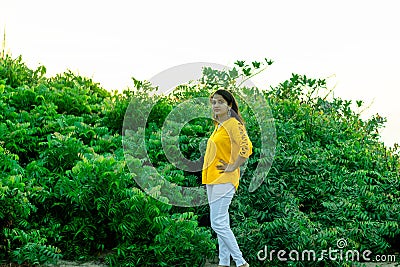 A beautiful Indian girl stood near a neem tree at sunrise Stock Photo