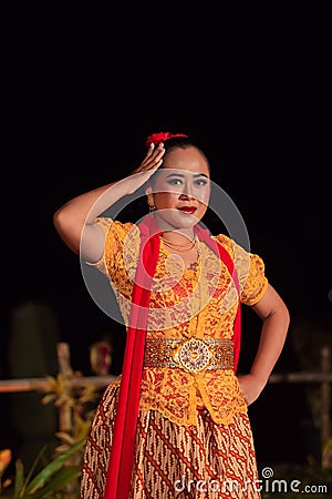 Beautiful Indonesian women wearing an orange traditional dance costume called kebaya when dancing a danced called jaipong Stock Photo