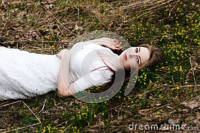 Beautiful innocent woman in white dress lying on the grass Stock Photo