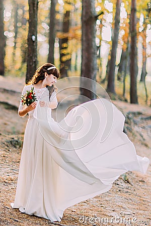 Beautiful innocent young brunette bride in gorgeous white dress at forest Stock Photo