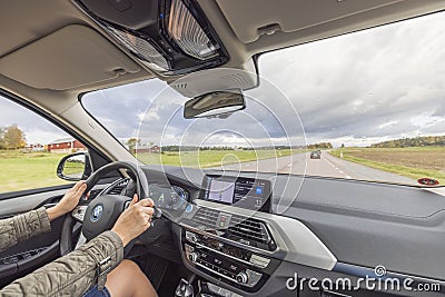 Beautiful interior view of BMWiX3 on road. Female driver in vehicle. Editorial Stock Photo