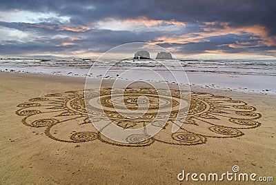 Intricate mandala sand art on a beach. Stock Photo