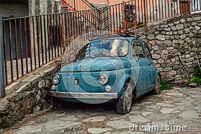 Beautiful Italian Charm in Rocca Imperiale: Vintage Blue Fiat 500 Abandoned on Stone Street Stock Photo