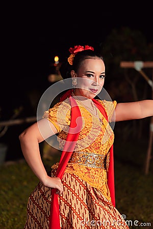 Beautiful Javanese woman with a golden necklace on her neck and golden belt on a yellow dress on their body Stock Photo