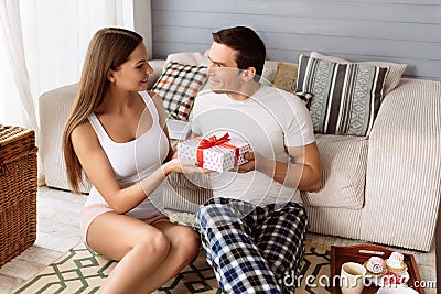 Beautiful joyful woman giving a present to his boyfriend Stock Photo