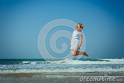 Beautiful Joyfull Girl Jumping on The Beach. Vacation and Relaxing Stock Photo