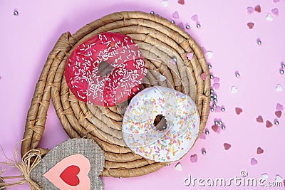 Beautiful juicy donuts with sweet plates on a decorative tray. Cupcake on a pink background with colorful hearts for kitchen Stock Photo