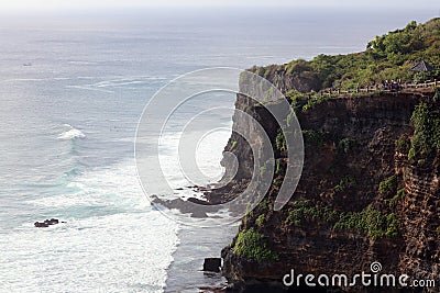 Beautiful jungle beach cliff with blue ocean at Bali Indonesia with yellow sand and green forest in the back. Stock Photo