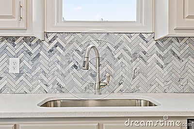 Beautiful kitchen sink with a silver faucet and tiled walls Editorial Stock Photo