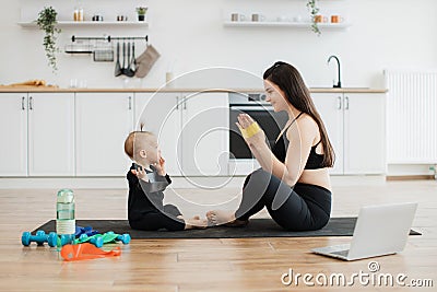 Baby learning exercises with stretch band from mom at home Stock Photo