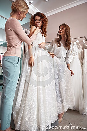 Beautiful lady fitting dress in wedding salon Stock Photo