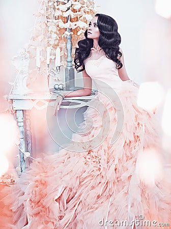 Beautiful lady in gorgeous couture dress in white interior Stock Photo