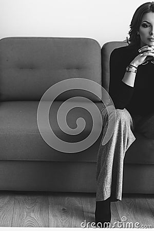 Beautiful lady in pants siting in room on sofa, gorgeous woman p Stock Photo