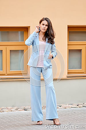 Beautiful lady in skyblue pantsuit on the street Stock Photo