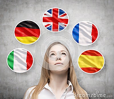 Beautiful lady is surrounded by bubbles with european countries' flags (Italian, German, Great Britain, French, Spanish). Stock Photo