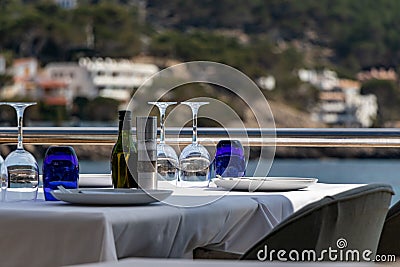 Beautiful laid table in a restaurant overlooking the mediterranean sea with sant elm in the background, mallorca, spain Stock Photo