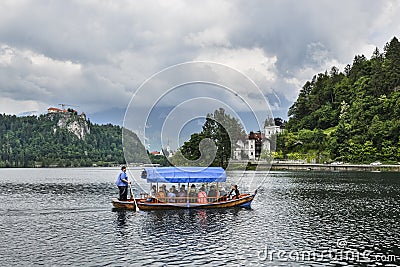 Beautiful Lake Bled in the Julian Alps and old wooden boat. Mountains, clear aquamarine water, tourist boat, lake and dramatic Editorial Stock Photo