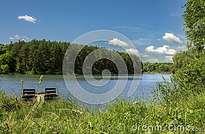 Beautiful lake and forest in the background, blue sky and white clouds Stock Photo