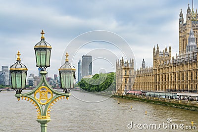 A beautiful lamppost on Westminster Bridge, the Palace of Westminster and the modern district across the River Thames, UK Editorial Stock Photo