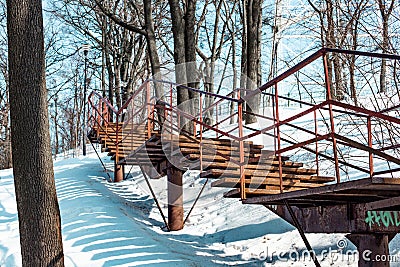 Beautiful landscape with an old rusty stairway in a snow-covered park Stock Photo