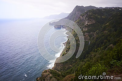 Sea and cliffs, pink lilly flowers and waterfall in Quinta do Furao, Santana, Madeira, Portugal Stock Photo