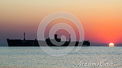 Beautiful landscape by the sea, at sunrise. The silhouette of a shipwreck Stock Photo